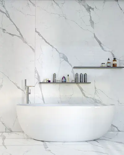 Bagno con vasca freestanding e pareti in gres effetto marmo Statuario bianco con venature grigie