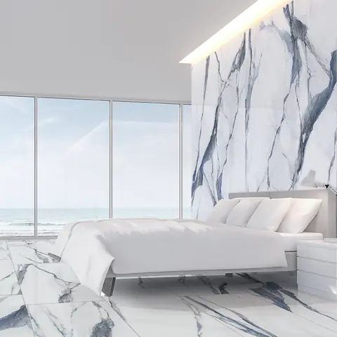 Camera da letto luminosa con pavimento e testata in gres effetto marmo Calacatta con venature blu