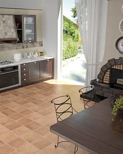 Cucina in stile rustico con pavimento in gres effetto cotto rosso e tavolo in legno scuro
