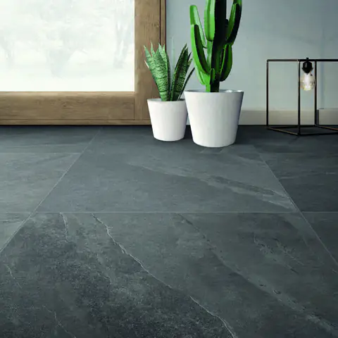 Pavimento in gres effetto pietra antracite con grandi vasi bianchi e piante grasse