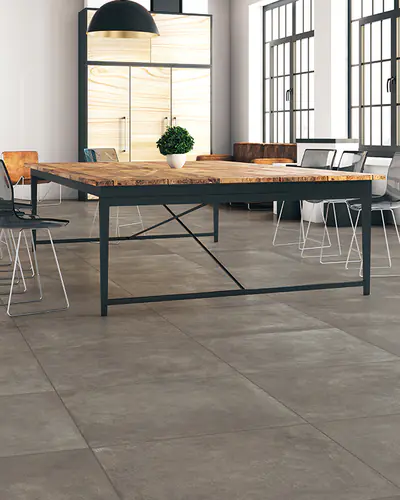 Sala da pranzo in stile loft con grandi vetrate e pavimento in piastrelle effetto cemento grigio