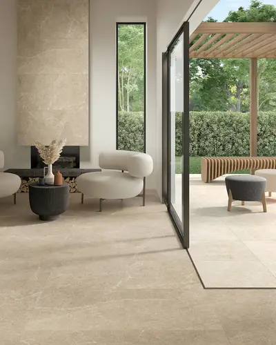 Soggiorno affacciato sul giardino con pavimento e parete in gres effetto pietra beige